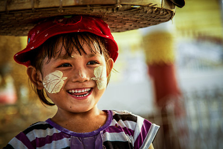 what to do to treat others in Myanmar - a baby Selling flowers with a smile