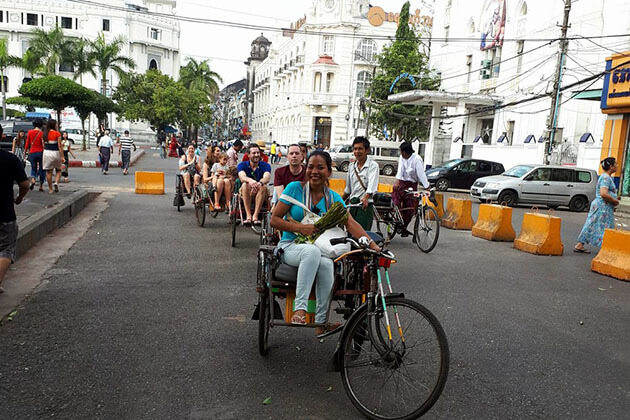 tourists riding trishaw to take yangon food tour