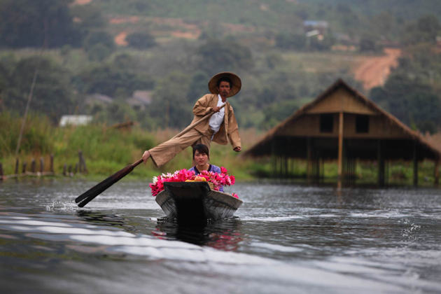 Leg rowing man with his wife on the way to the market, Inle