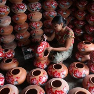 a local artisan is making a pot in the pottery workshop in Twante