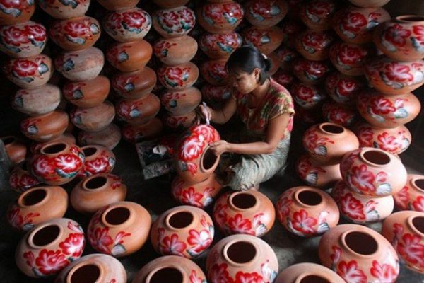 a local artisan is making a pot in the pottery workshop in Twante