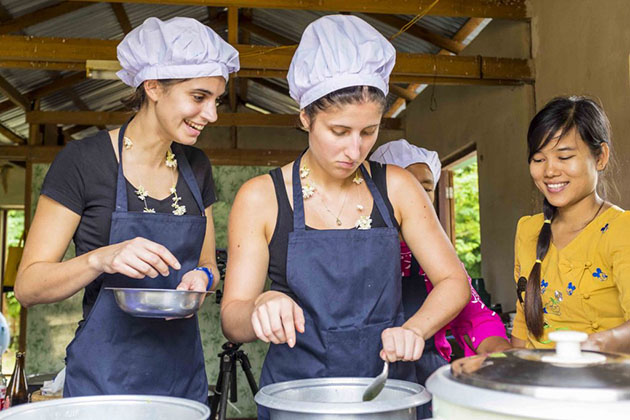 tourists learn how to cook the traditional dish of Intha people